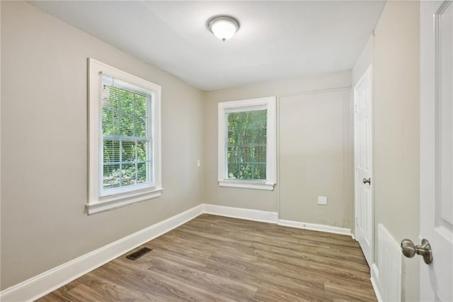 spare room featuring plenty of natural light and hardwood / wood-style floors