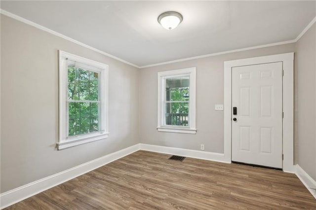 spare room featuring wood-type flooring and crown molding