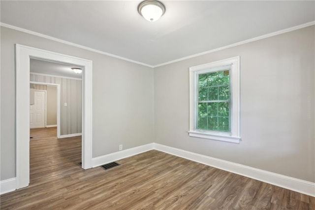 spare room featuring crown molding and dark hardwood / wood-style floors