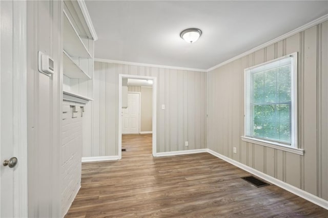 unfurnished room with ornamental molding and hardwood / wood-style flooring