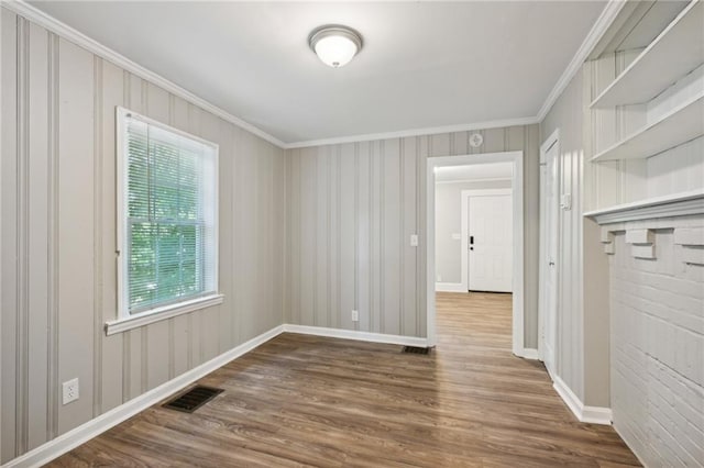 unfurnished room featuring wood-type flooring and crown molding