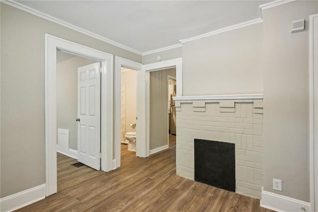 unfurnished living room featuring a fireplace, wood-type flooring, and ornamental molding