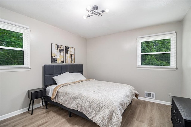 479 Charter Oak Dr SW, Atlanta, GA 30331 - bedroom with light wood finished floors, multiple windows, baseboards, and a chandelier