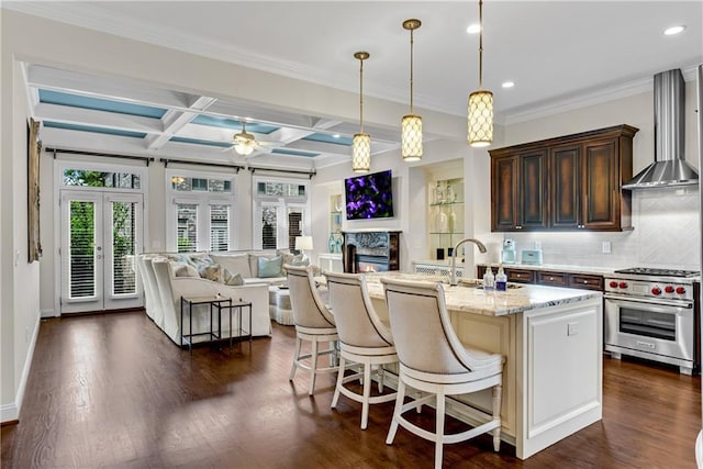 3663 Brookhaven Manor Xing NE, Atlanta, GA 30319 - kitchen featuring designer range, wall chimney range hood, backsplash, a breakfast bar, and open floor plan