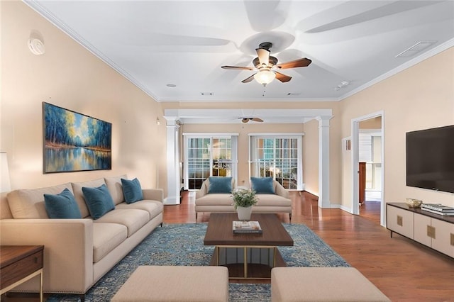 living area featuring ornamental molding, wood finished floors, and decorative columns