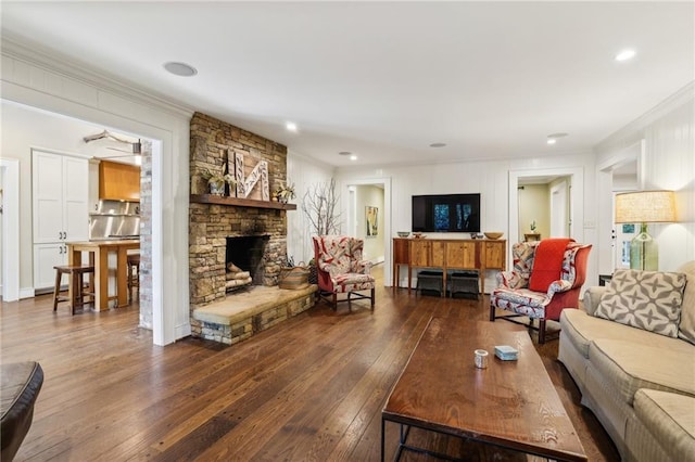 living area with crown molding, a fireplace, and dark wood finished floors