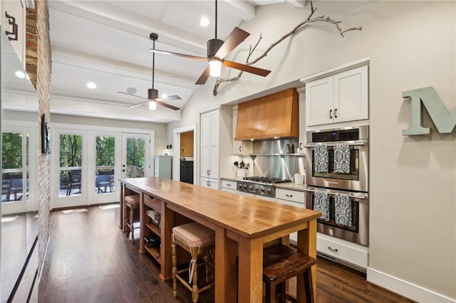 kitchen featuring ceiling fan, dark wood-type flooring, french doors, lofted ceiling with beams, and stainless steel appliances