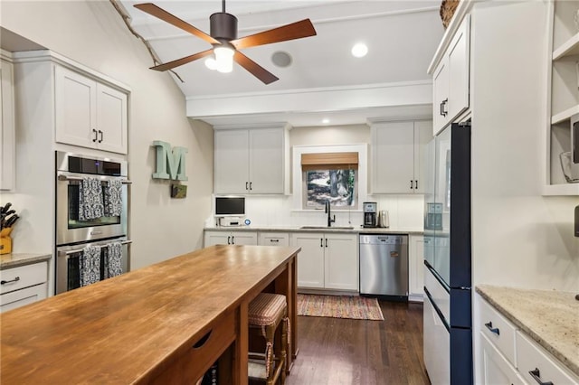 kitchen with open shelves, a sink, a ceiling fan, dark wood finished floors, and appliances with stainless steel finishes