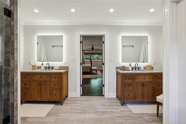 ensuite bathroom featuring a sink, crown molding, and connected bathroom