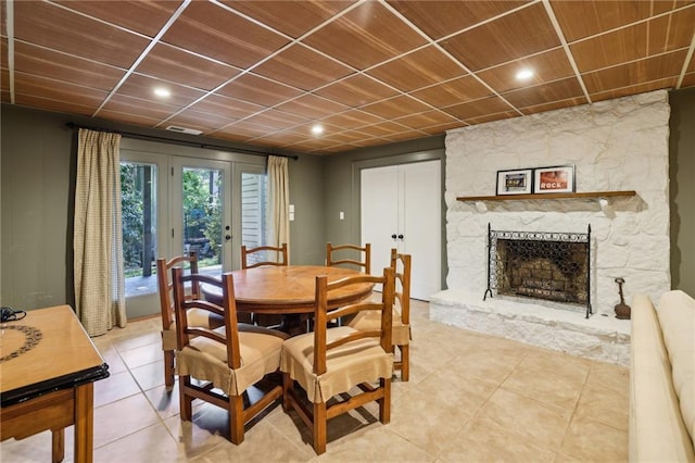 dining room featuring light tile patterned floors, recessed lighting, and a stone fireplace