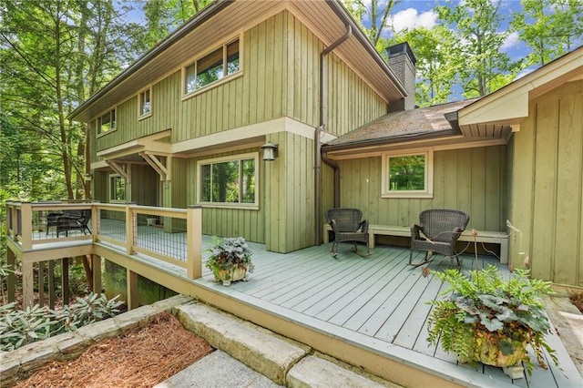 back of property with a wooden deck and a chimney