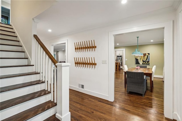 stairway featuring recessed lighting, ornamental molding, baseboards, and wood finished floors