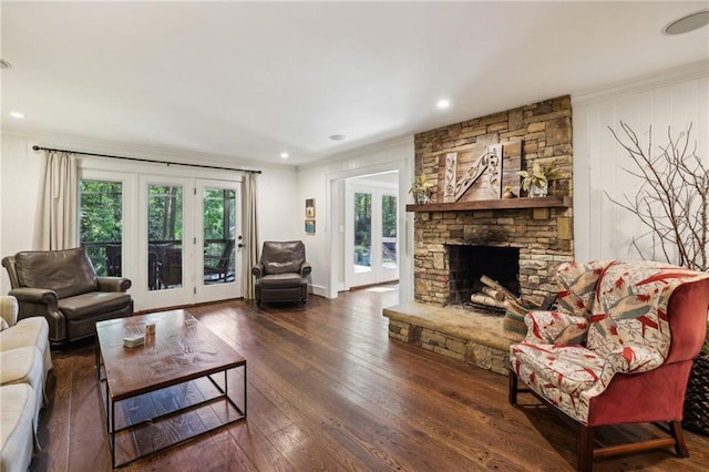 living room with wood-type flooring, ornamental molding, recessed lighting, and a fireplace