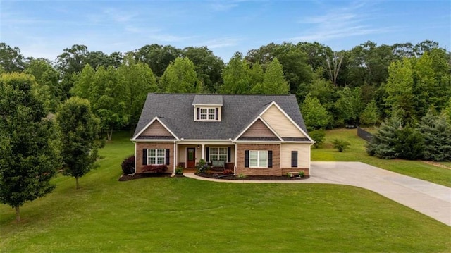 craftsman inspired home featuring brick siding, covered porch, and a front lawn