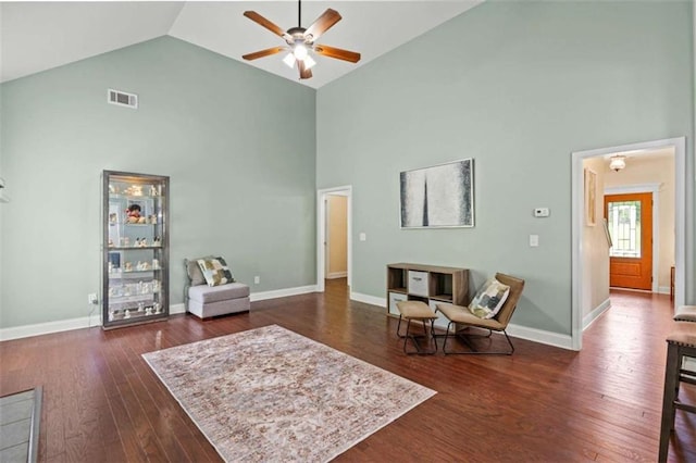 sitting room with high vaulted ceiling, ceiling fan, dark wood-type flooring, and baseboards