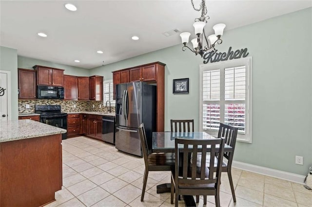 kitchen featuring black appliances, backsplash, a chandelier, a sink, and hanging light fixtures