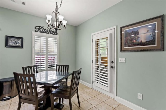dining space featuring a chandelier, light tile patterned floors, and baseboards