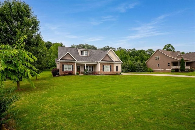 craftsman-style home featuring brick siding and a front yard