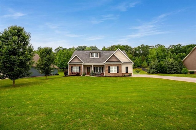 craftsman-style home with brick siding, a front yard, and covered porch