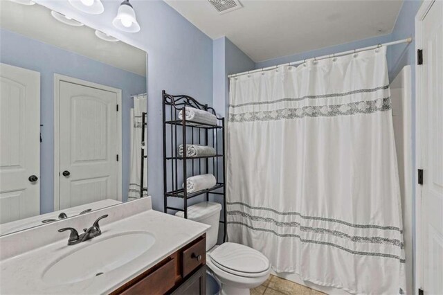 bathroom with toilet, vanity, and a shower with curtain