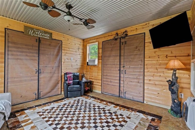 foyer entrance with wood walls and ceiling fan