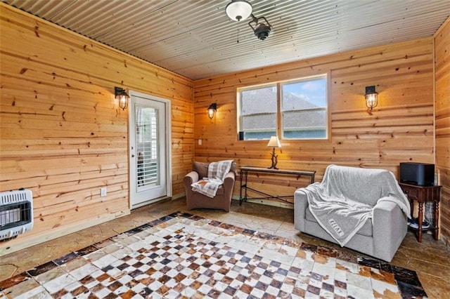 sitting room with heating unit and wood walls