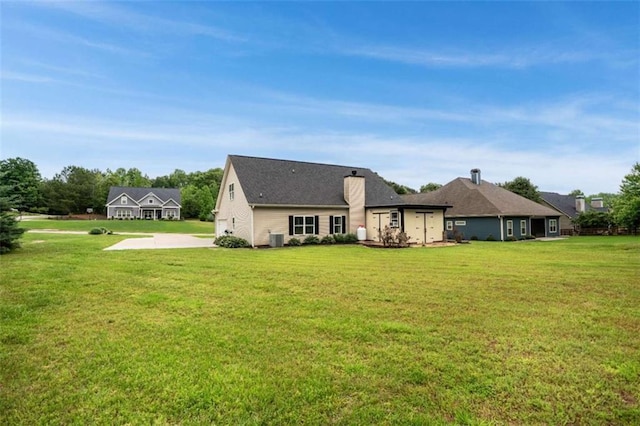 back of house featuring a yard, central AC unit, and driveway