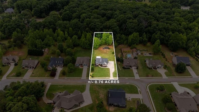 aerial overview of property's location with a heavily wooded area, nearby suburban area, and property parcel outlined
