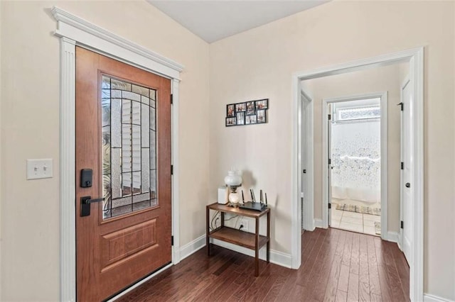 foyer with dark wood-style floors and baseboards