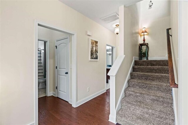 stairs featuring wood finished floors and baseboards
