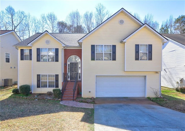 split foyer home featuring a garage, central AC, and concrete driveway