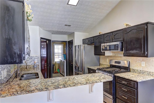 kitchen with a sink, stainless steel appliances, tasteful backsplash, and visible vents