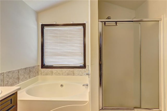 bathroom featuring lofted ceiling, a garden tub, a shower stall, and vanity