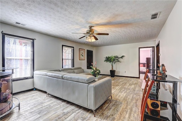 living area with visible vents, plenty of natural light, and light wood-type flooring