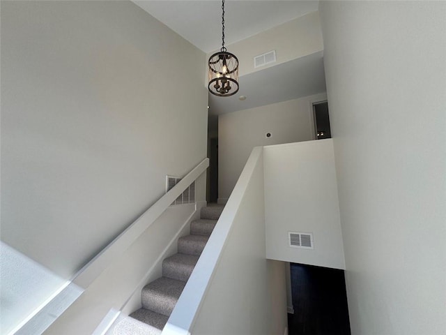 stairs with an inviting chandelier