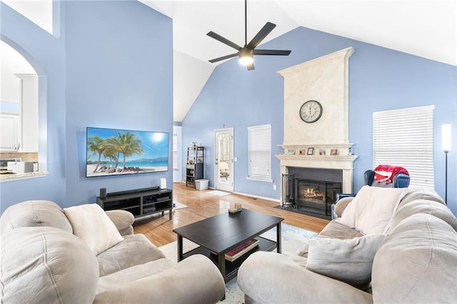 living room with ceiling fan, high vaulted ceiling, and light hardwood / wood-style floors