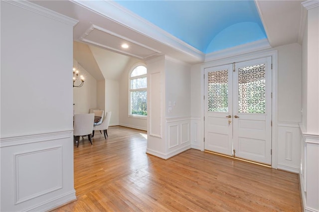 4252 Tall Hickory Trl, Gainesville, GA 30506 - foyer entrance featuring lofted ceiling, light wood-style floors, a decorative wall, a chandelier, and a wainscoted wall