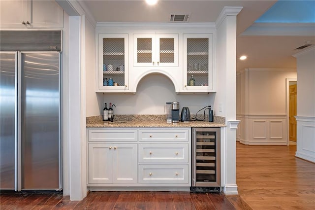 4252 Tall Hickory Trl, Gainesville, GA 30506 - indoor wet bar featuring wine cooler, built in refrigerator, dark wood-style flooring, and crown molding