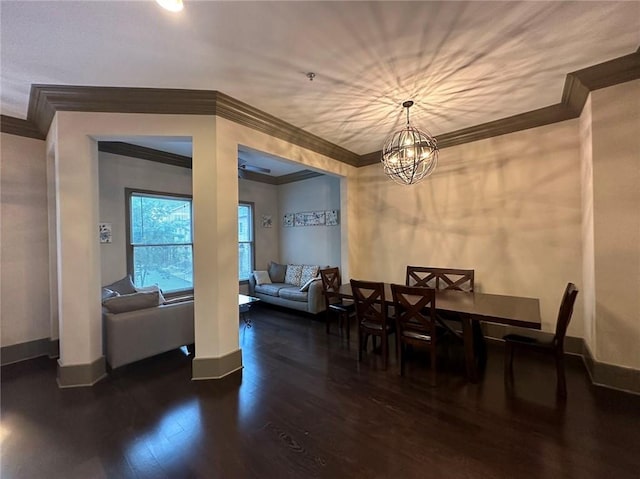 dining space with an inviting chandelier, crown molding, wood finished floors, and baseboards