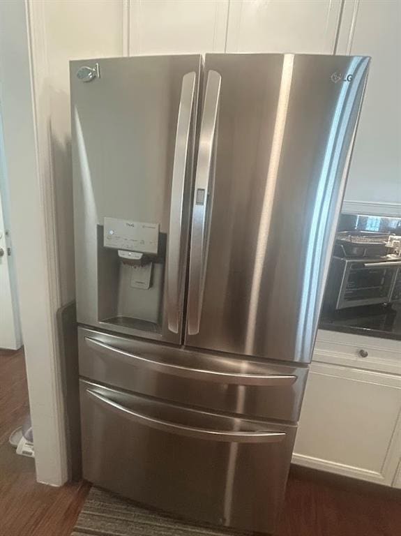 3311 Lindenridge Dr, Buford, GA 30519 - room details featuring dark wood-style flooring, stainless steel refrigerator with ice dispenser, dark countertops, and white cabinetry