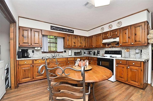 kitchen featuring tasteful backsplash, wood-type flooring, crown molding, and white electric stove