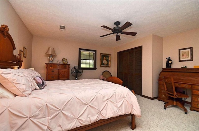 carpeted bedroom featuring a closet, a textured ceiling, and ceiling fan