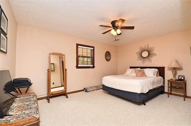 carpeted bedroom featuring ceiling fan and a textured ceiling