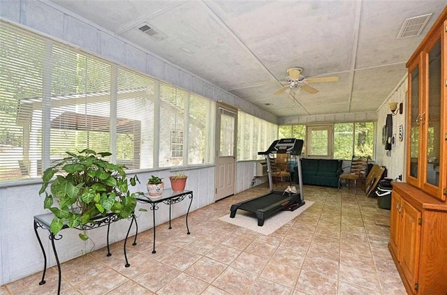 workout room featuring ceiling fan, light tile patterned flooring, and a healthy amount of sunlight