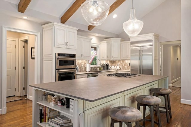7265 Hunters Branch Dr, Sandy Springs, GA 30328 - kitchen featuring appliances with stainless steel finishes, dark wood finished floors, backsplash, a kitchen island, and decorative light fixtures