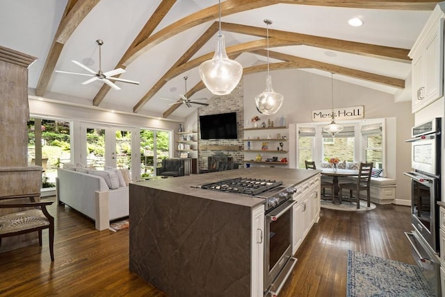 7265 Hunters Branch Dr, Sandy Springs, GA 30328 - kitchen featuring ceiling fan, stainless steel appliances, a brick fireplace, white cabinets, and beam ceiling