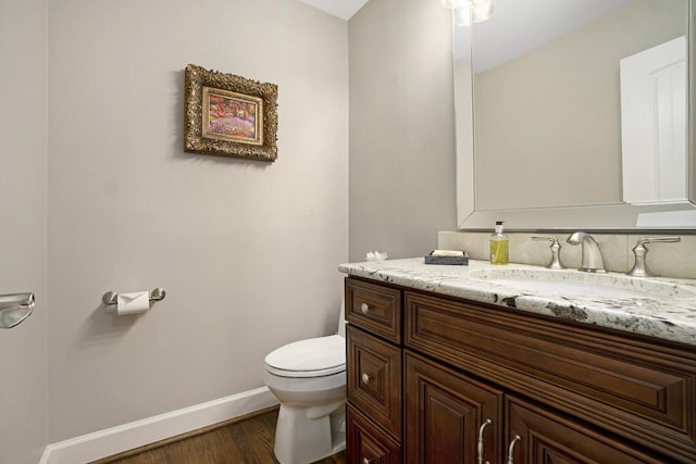 7265 Hunters Branch Dr, Sandy Springs, GA 30328 - half bath with toilet, vanity, wood finished floors, and baseboards