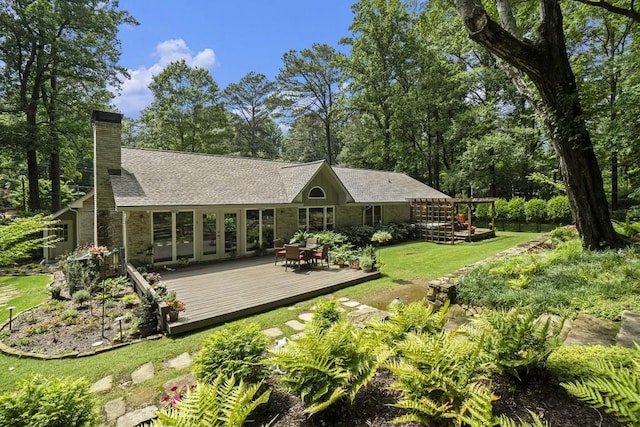 7265 Hunters Branch Dr, Sandy Springs, GA 30328 - rear view of house featuring a deck, stone siding, a chimney, a shingled roof, and a yard