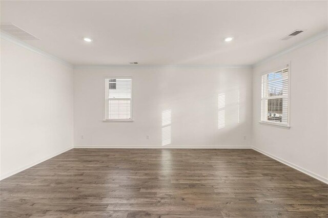 empty room featuring dark wood-type flooring and ornamental molding