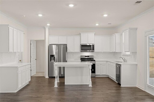 kitchen featuring white cabinets, dark hardwood / wood-style flooring, a center island, and stainless steel appliances